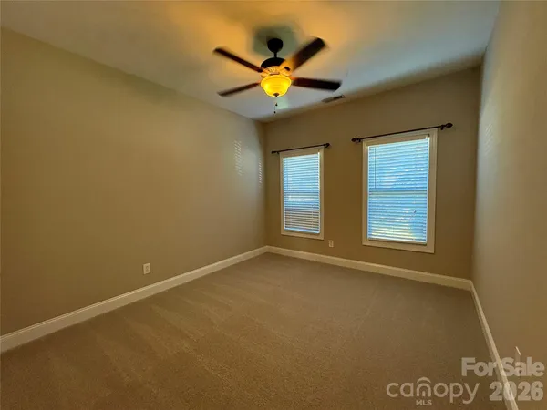 an empty room with window and ceiling fan