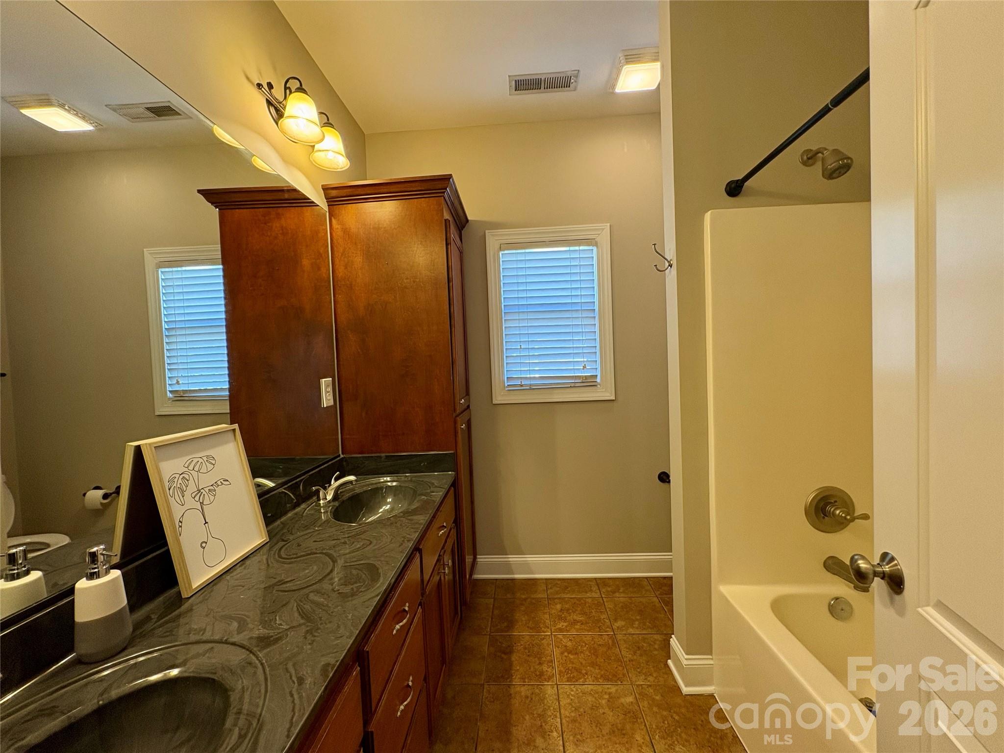 402 Church Street Locust, NC 28097 - Photo 25 of 39 a bathroom with a granite countertop sink a mirror and shower