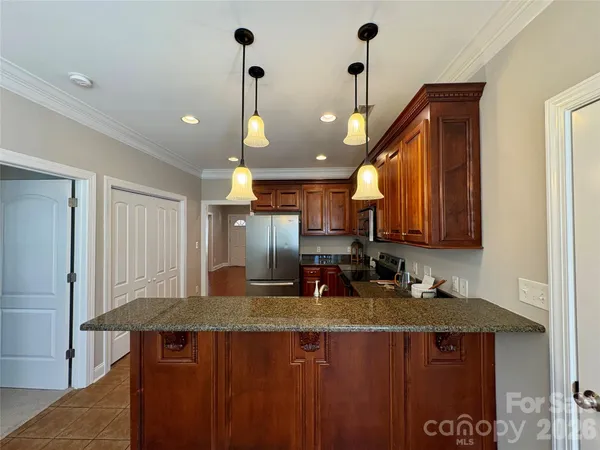 a kitchen with stainless steel appliances granite countertop a sink a stove and a refrigerator