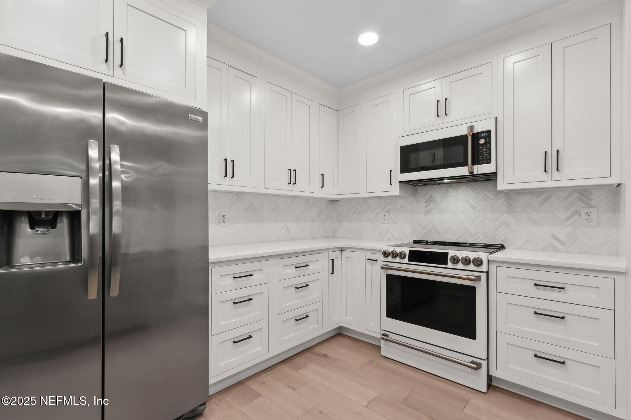 1908 Springbrook Road Fernandina Beach, FL 32034 - Photo 22 of 48 a kitchen with white cabinets stainless steel appliances and a refrigerator