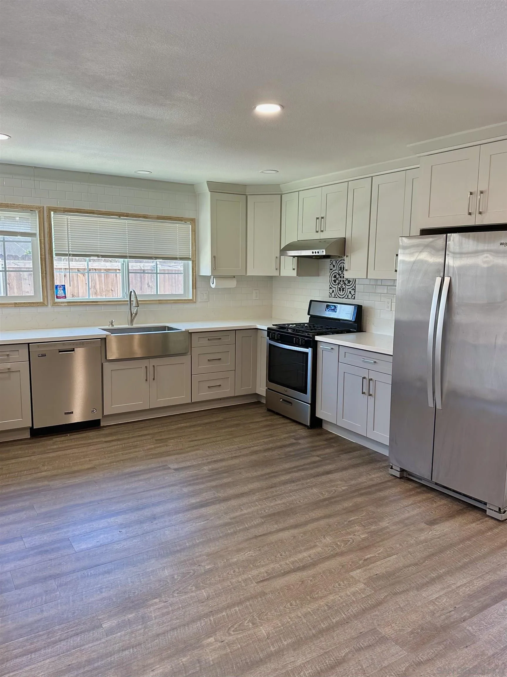 10762 Fenwick Road San Diego, CA 92126 - Photo 3 of 10 a large kitchen with stainless steel appliances granite countertop a stove a sink dishwasher and a refrigerator