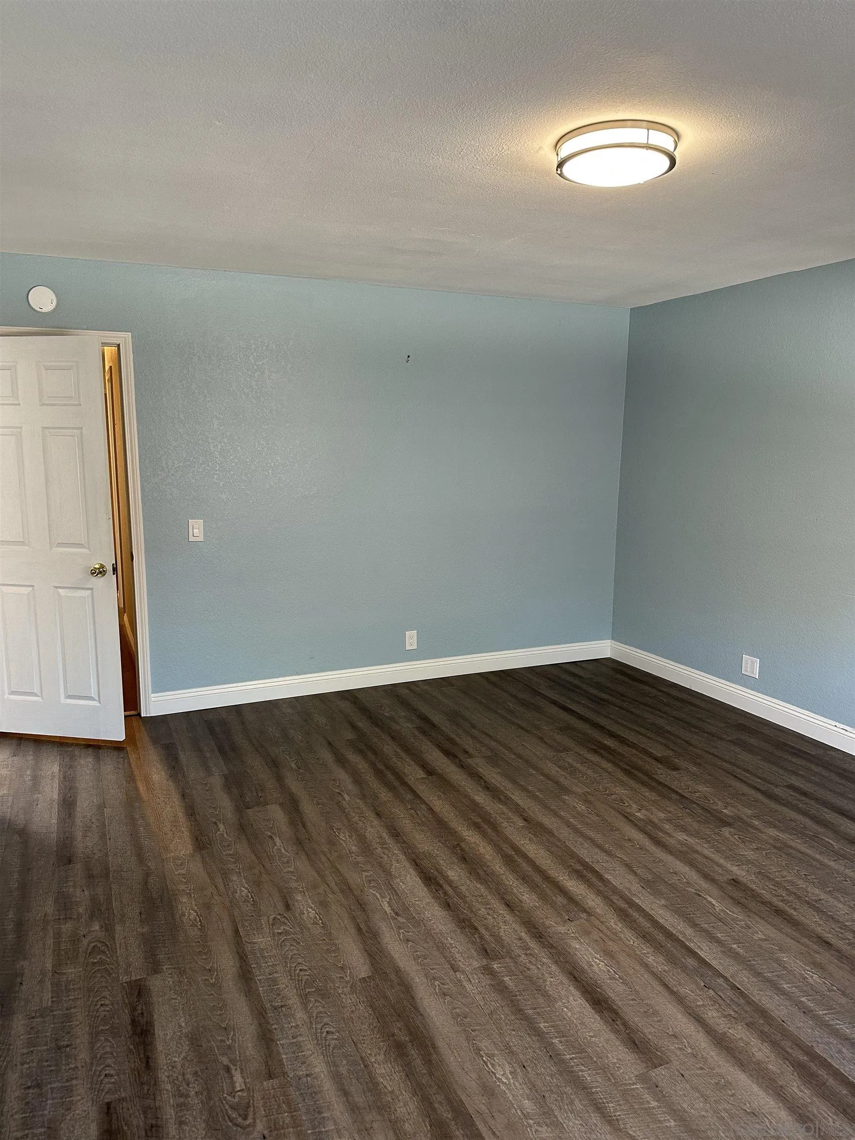 10762 Fenwick Road San Diego, CA 92126 - Photo 5 of 10 a view of an empty room with wooden floor and a window