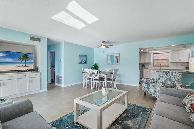 a living room with furniture and a dining table with kitchen view