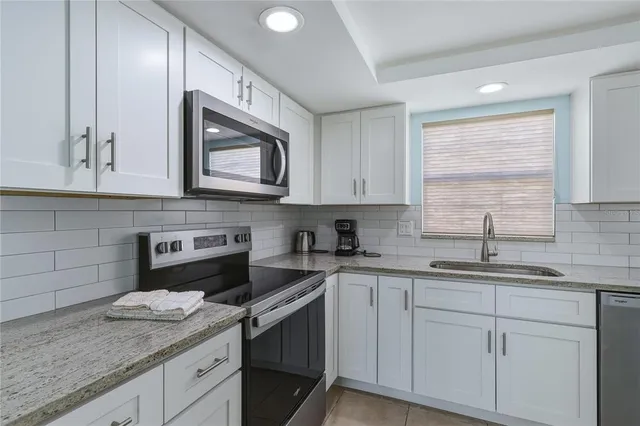 a kitchen with stainless steel appliances granite countertop white cabinets sink and dishwasher