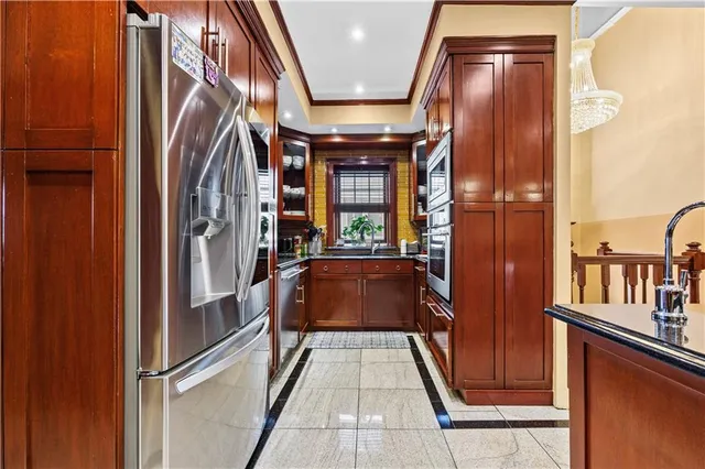 a kitchen with stainless steel appliances granite countertop a refrigerator and wooden cabinets