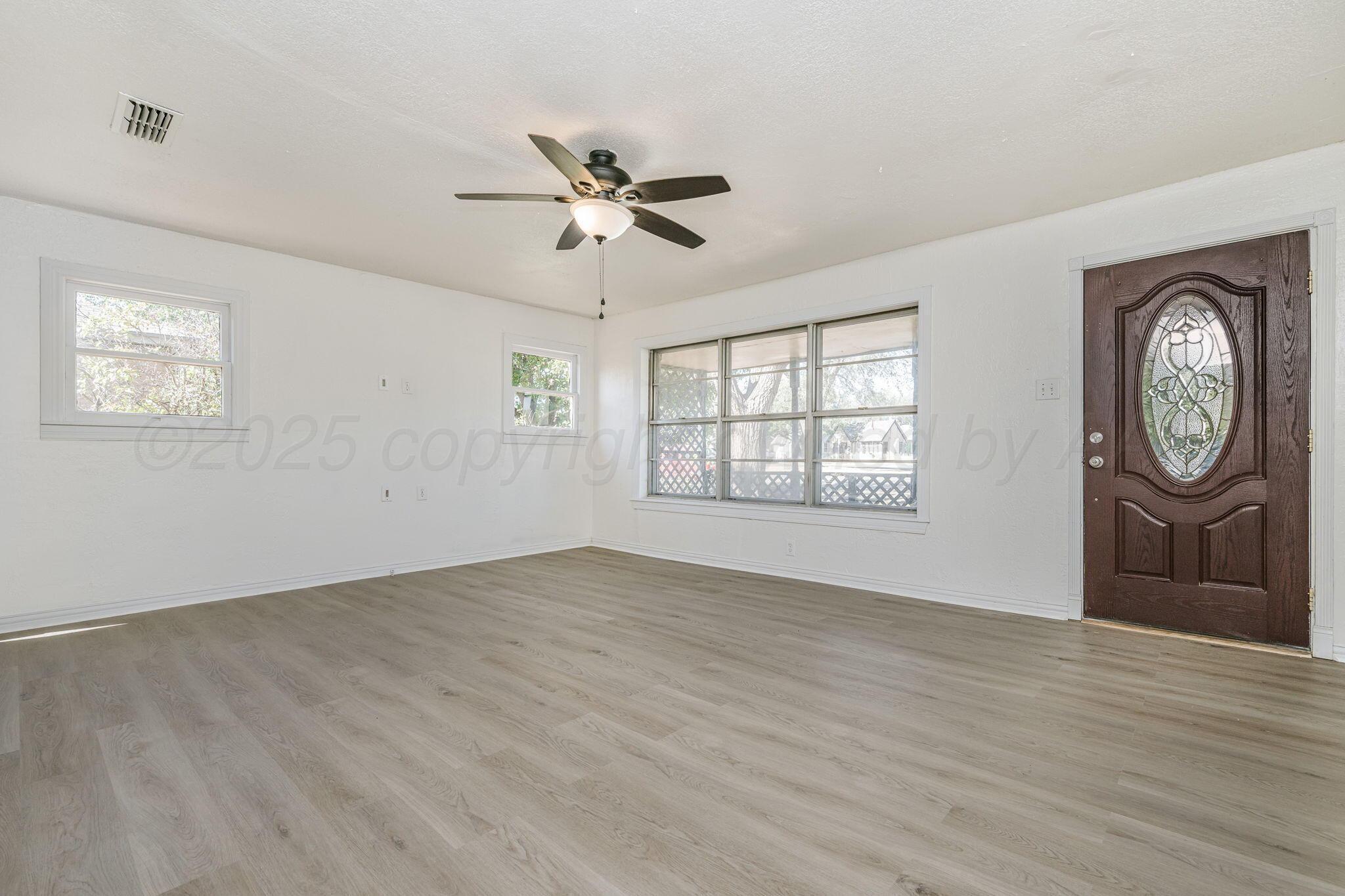 606 Sunset Terrace Amarillo, TX 79106 - Photo 2 of 16 a view of an empty room with window and wooden floor