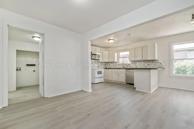 a view of a kitchen with a sink and a large window