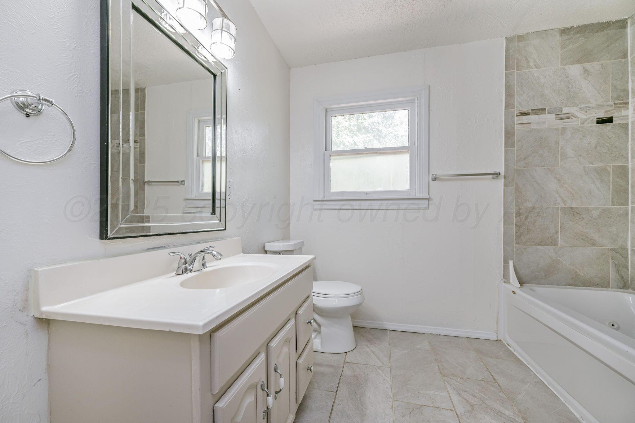 606 Sunset Terrace Amarillo, TX 79106 - Photo 9 of 16 a bathroom with a sink toilet double vanity and tub