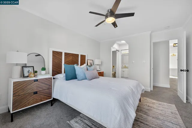 a bedroom with a bed chandelier and a window