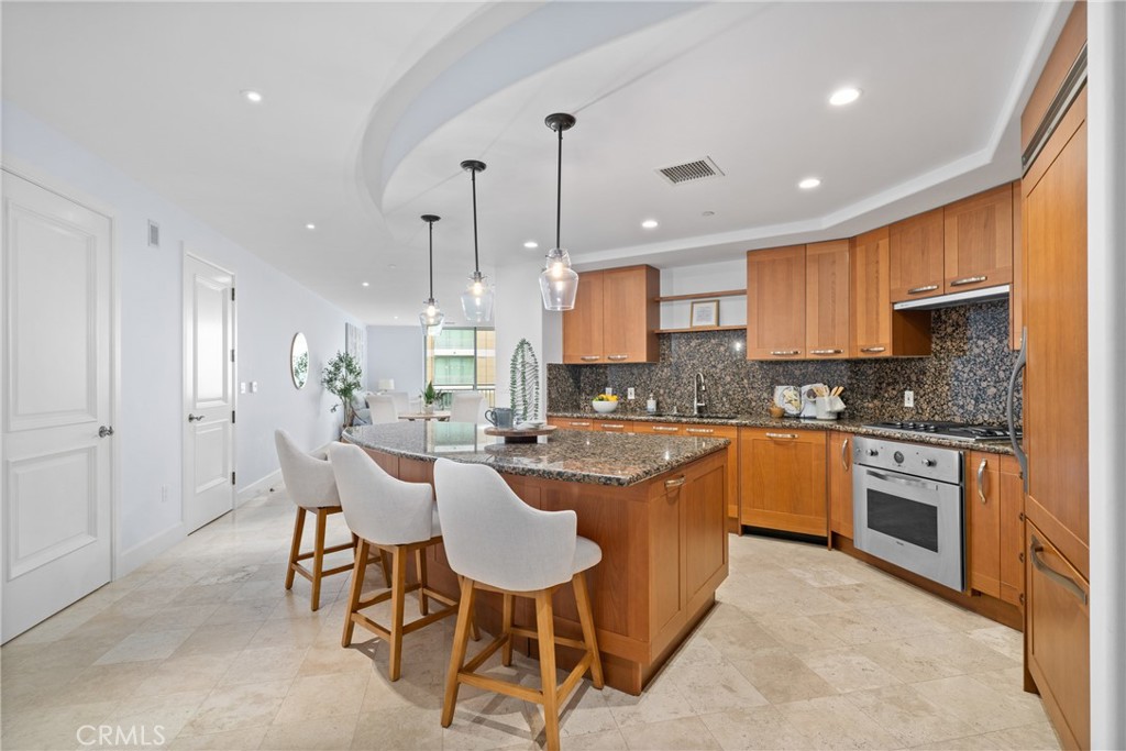 5082 Scholarship Irvine, CA 92612 - Photo 4 of 30 a kitchen with stainless steel appliances granite countertop wooden cabinets a stove a sink and a refrigerator