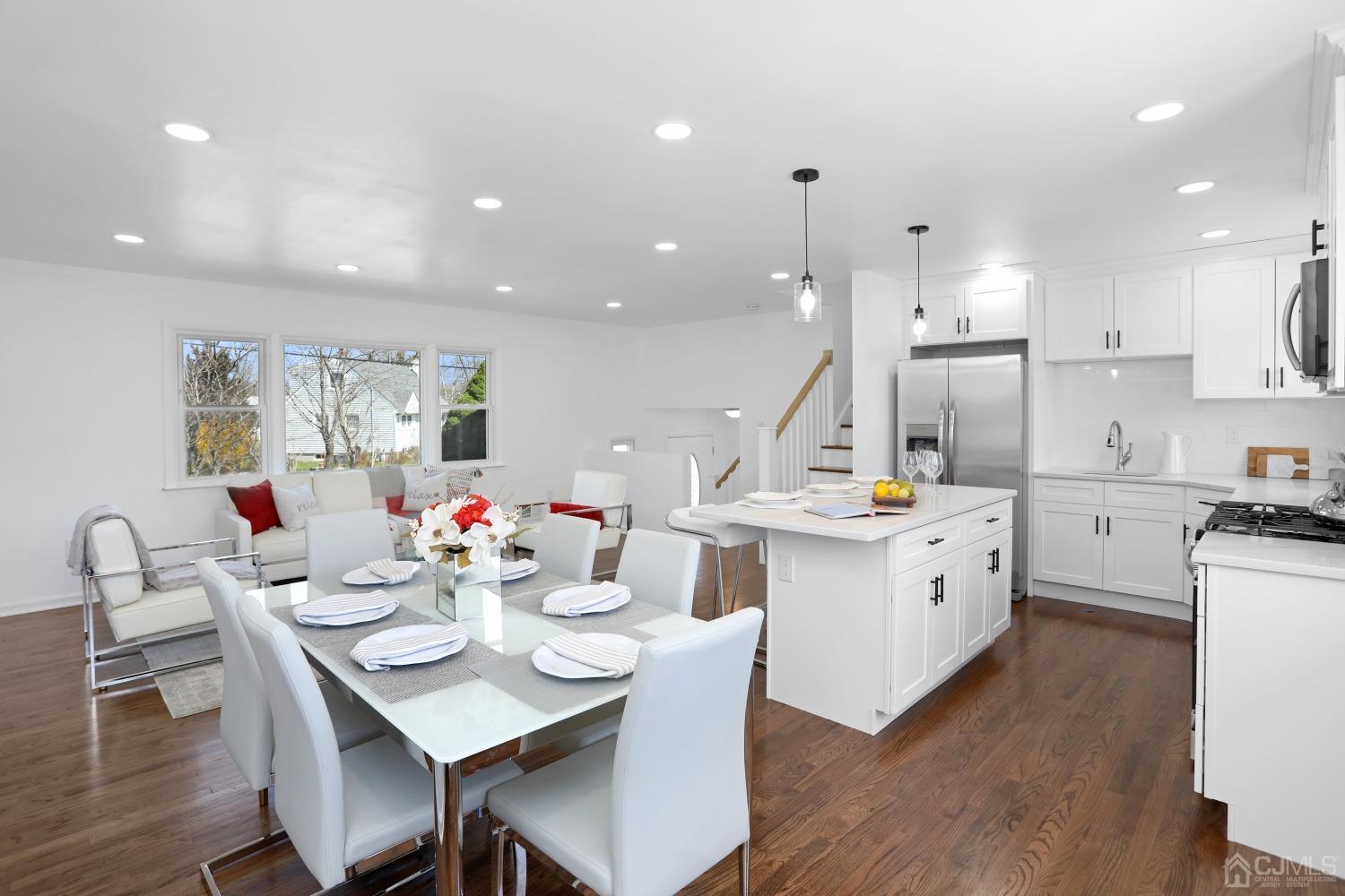 25 Mercer Road Old Bridge, NJ 08857 - Photo 5 of 30 a open dining room with stainless steel appliances kitchen island a table chairs a sink dishwasher and a refrigerator with wooden floor