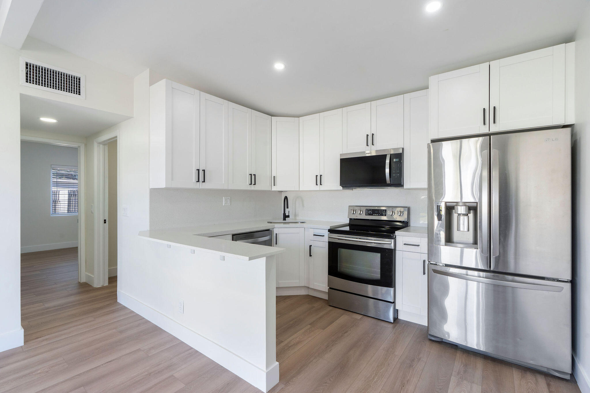 5580 Maypop Road West Palm Beach, FL 33415 - Photo 7 of 41 a kitchen with stainless steel appliances a refrigerator stove and wooden floor