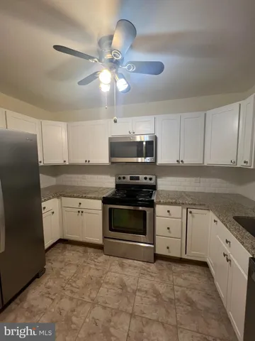 a kitchen with stainless steel appliances granite countertop a stove cabinets and a refrigerator