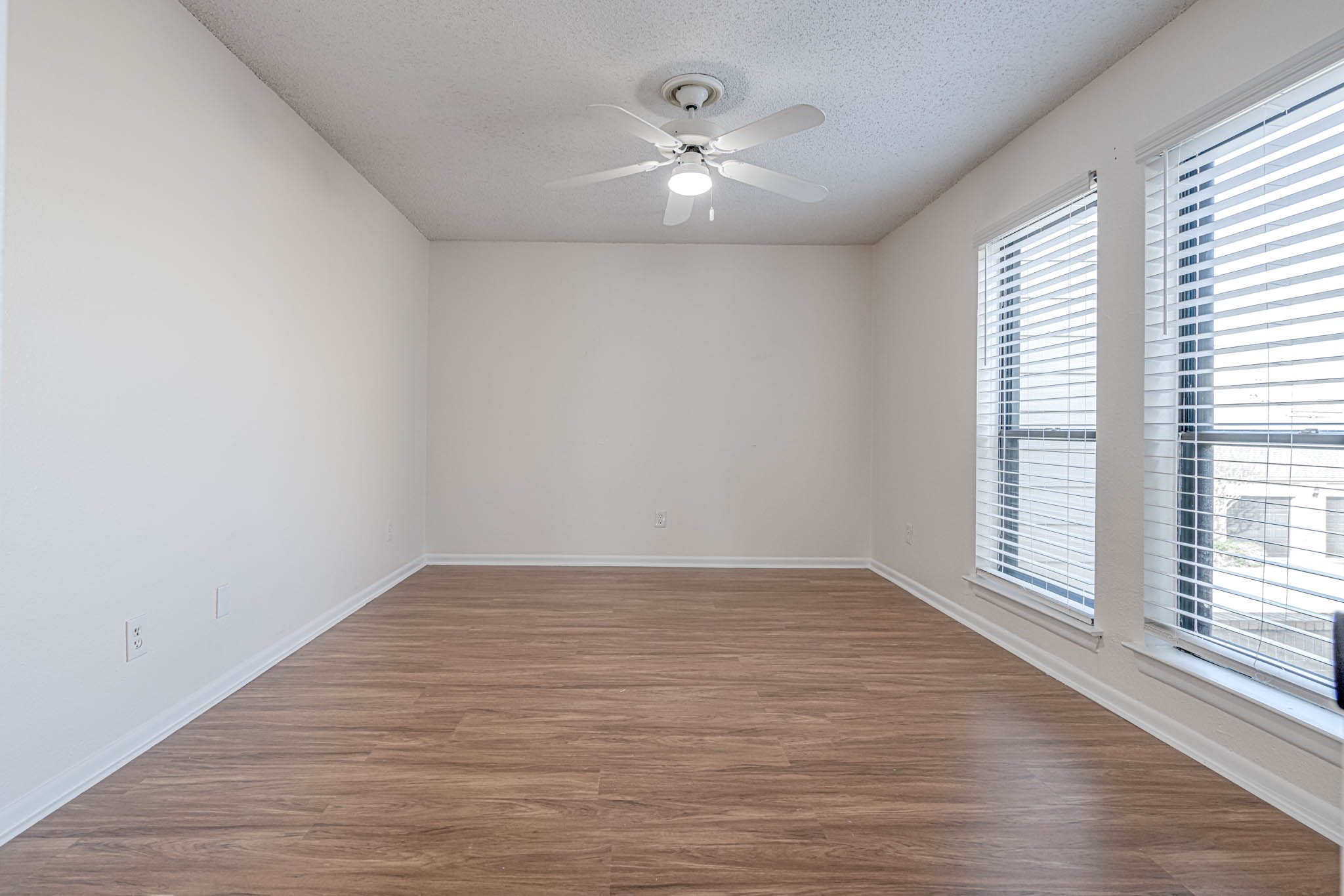2277 South Kirkwood Road, Unit 4/808 Houston, TX 77077 - Photo 12 of 23 Bright room with wood like flooring, neutral walls, and large windows for natural light. Ceiling fan included for comfort.