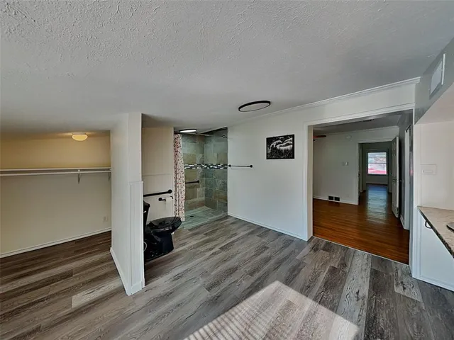 a view of empty room with wooden floor