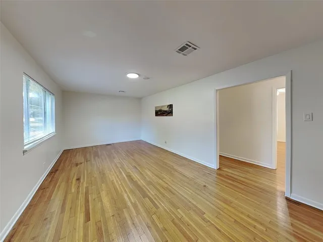 a view of empty room with wooden floor