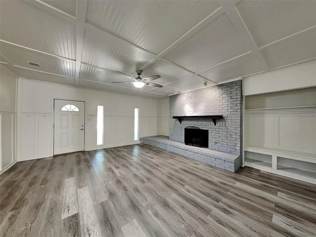 an empty room with wooden floor and fireplace