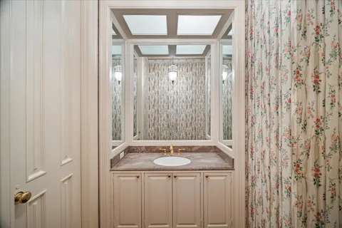 a bathroom with a granite countertop sink and a mirror