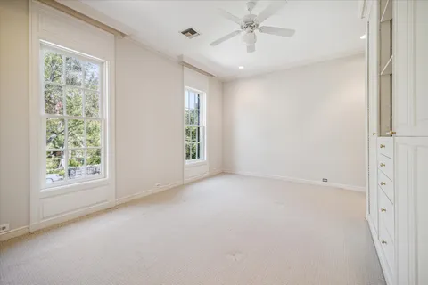 an empty room with a window and a fan
