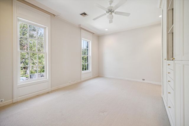 an empty room with a window and a fan