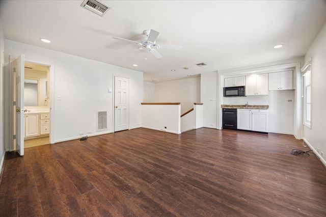an empty room with windows and ceiling fan