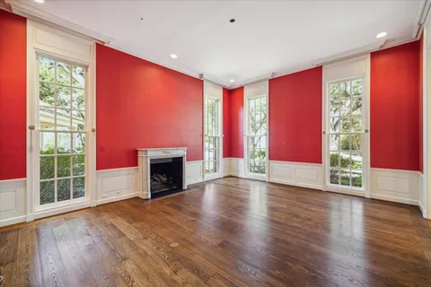wooden floor fireplace and windows in an empty room