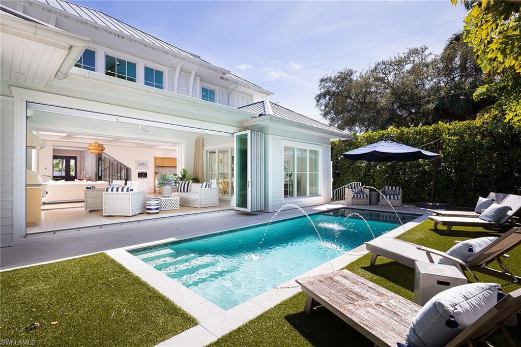 1040 2nd Street South Naples, FL 34102 - Photo 11 of 42 a view of a patio with table and chairs barbeque potted plants and large tree