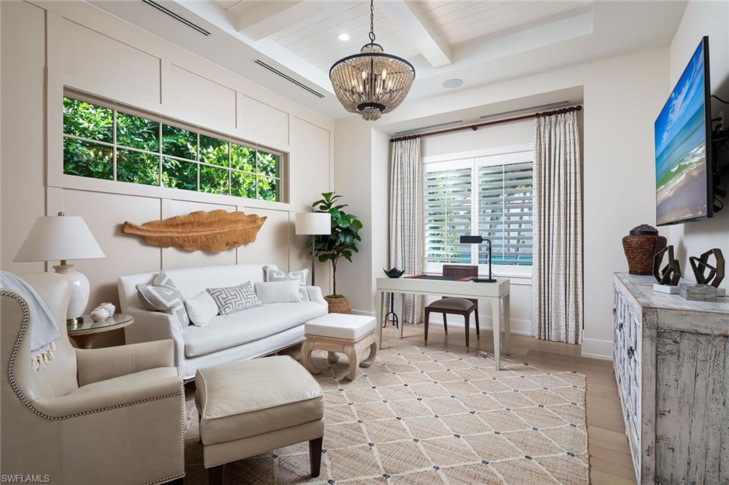 1040 2nd Street South Naples, FL 34102 - Photo 18 of 42 a living room with furniture a fireplace and a chandelier