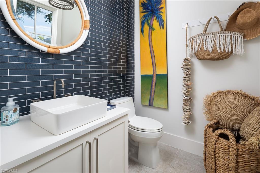 1040 2nd Street South Naples, FL 34102 - Photo 34 of 42 a bathroom with a toilet a sink and mirror