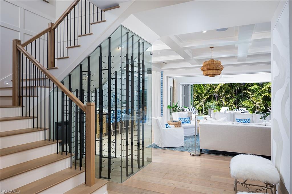 1040 2nd Street South Naples, FL 34102 - Photo 10 of 42 a living room with couches and a dining table with wooden floor