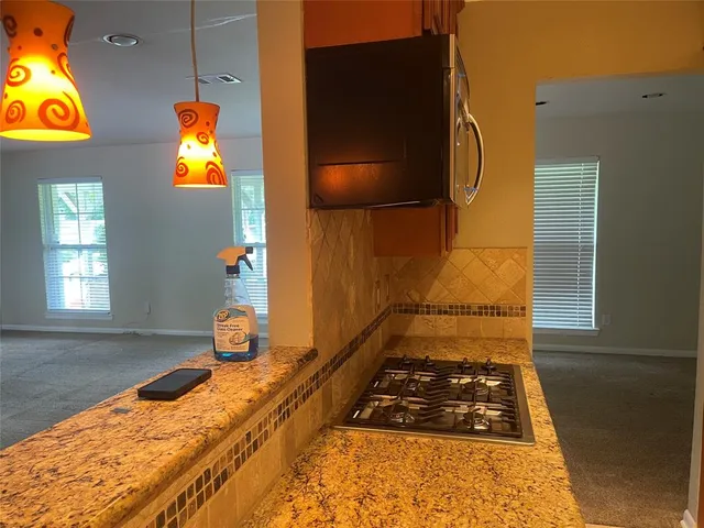 a kitchen with stainless steel appliances granite countertop a refrigerator and a stove top oven