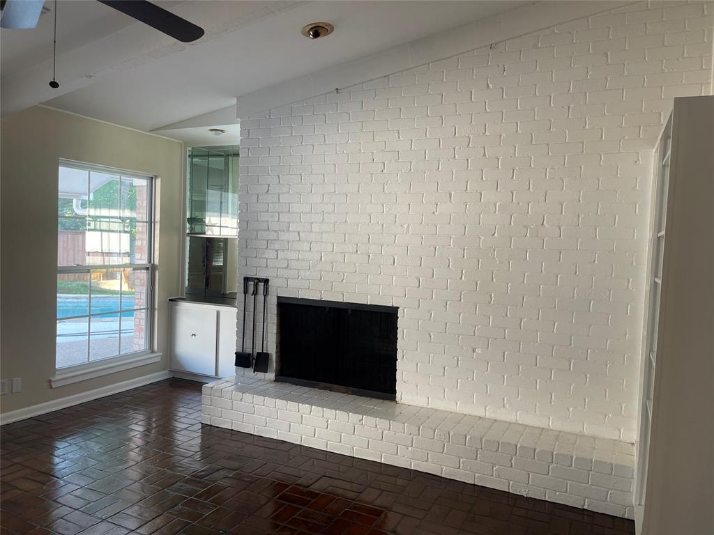 13308 Purple Sage Road Dallas, TX 75240 - Photo 8 of 18 an empty room with wooden floor and fireplace