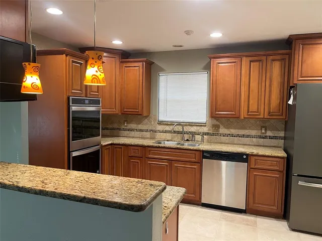 a kitchen with stainless steel appliances granite countertop a sink stove and refrigerator