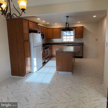 a kitchen with stainless steel appliances granite countertop a refrigerator a sink and a stove