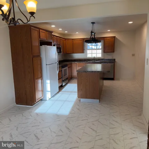 a kitchen with stainless steel appliances granite countertop a refrigerator a sink and a stove