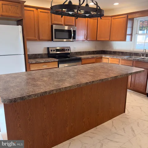 a kitchen with stainless steel appliances granite countertop a sink a stove and a microwave