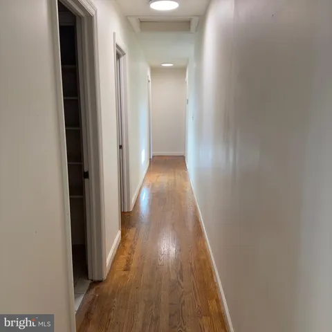 a view of a hallway with wooden floor