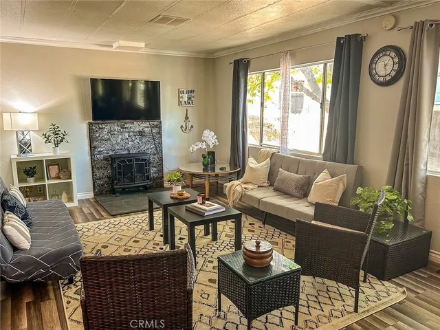 a living room with furniture a fireplace a flat screen tv and a large window