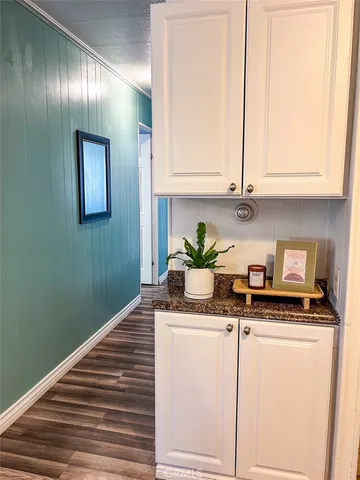 a room with granite countertop cabinets and black appliances