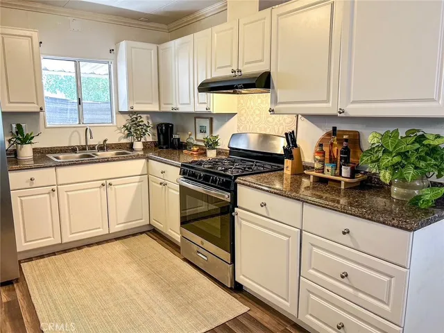 a kitchen with granite countertop white cabinets and white appliances