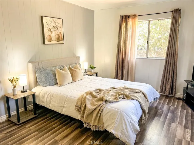 a bedroom with a bed and wooden floor