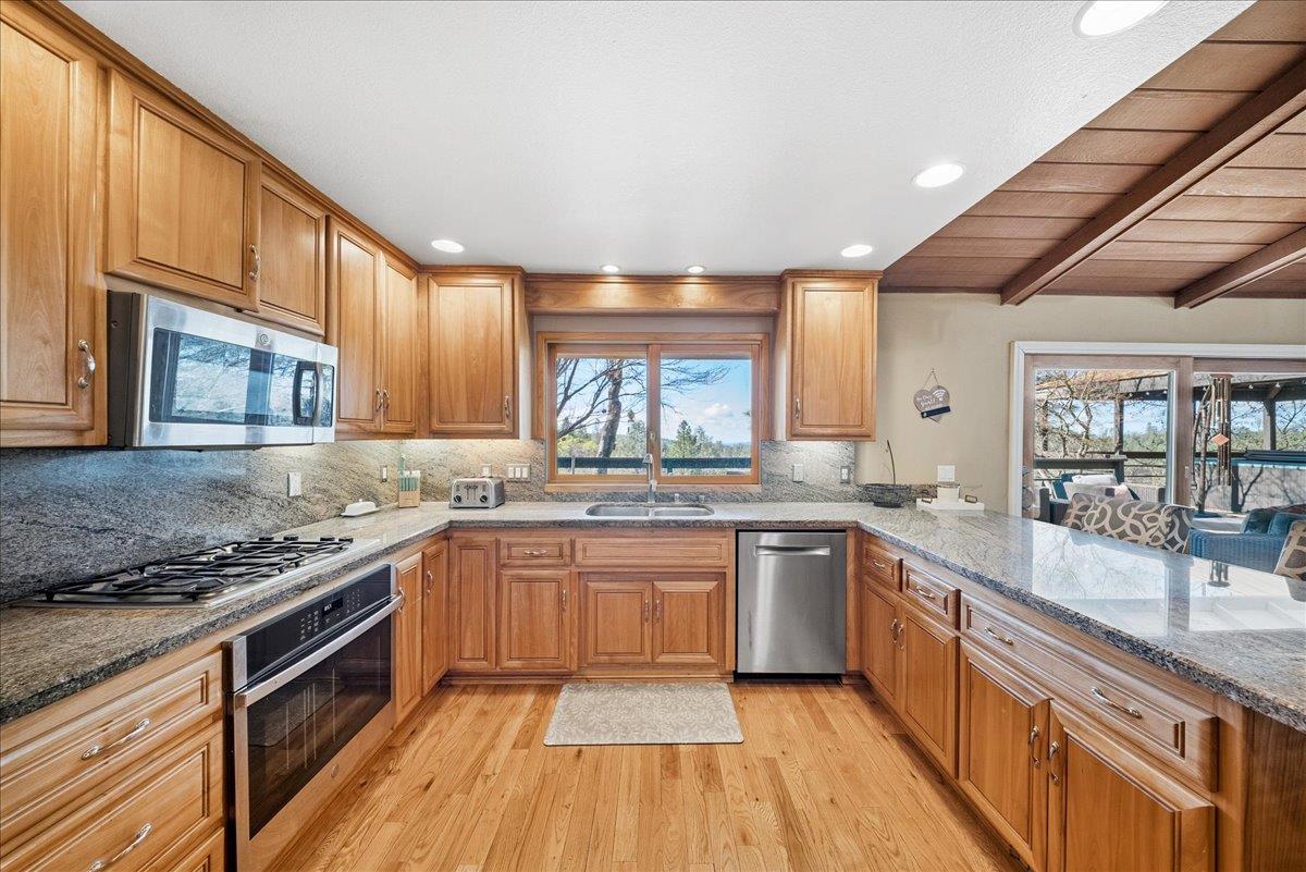 16035 Running Springs Road Grass Valley, CA 95949 - Photo 12 of 94 a kitchen with stainless steel appliances granite countertop hardwood floor sink stove and wooden cabinets