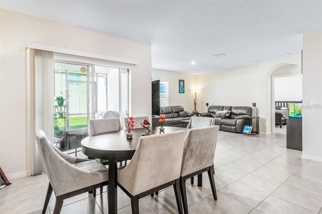 5381 Hickory Downs Way St. Cloud, FL 34771 - Photo 13 of 35 a view of a dining room with furniture and a potted plant