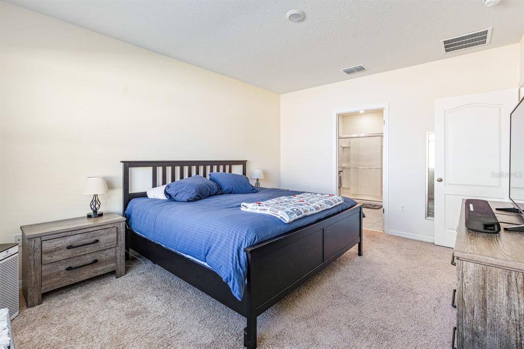 5381 Hickory Downs Way St. Cloud, FL 34771 - Photo 18 of 35 a spacious bedroom with a bed and a couch
