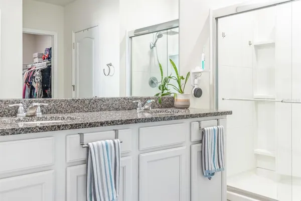 a bathroom with a granite countertop sink and a mirror