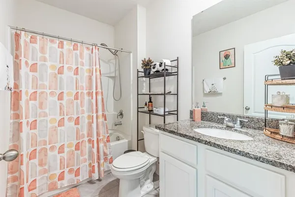 a bathroom with a granite countertop sink a toilet and a mirror