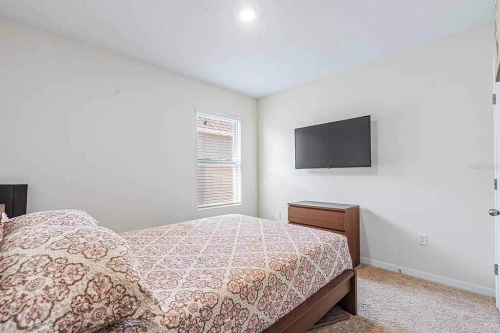 5381 Hickory Downs Way St. Cloud, FL 34771 - Photo 23 of 35 a bedroom with a bed and a flat screen tv