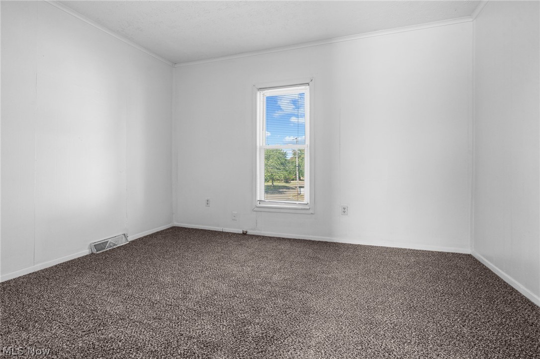 2387 29th Street Southwest Akron, OH 44314 - Photo 18 of 24 Carpeted spare room with baseboards and crown molding