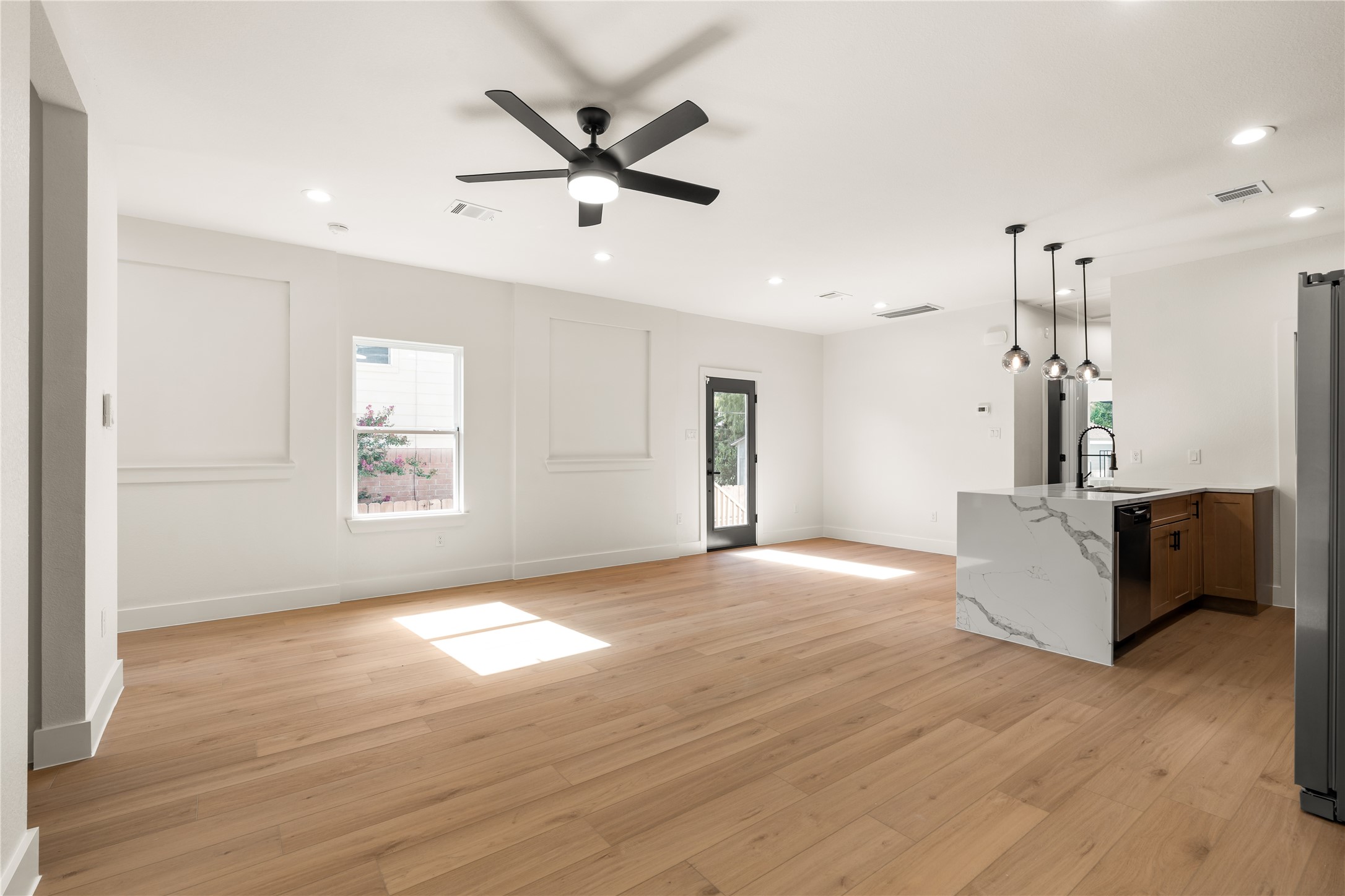 5321 Rue Street Houston, TX 77033 - Photo 6 of 23 Chef's kitchen overlooking the living zone — waterfall edge quartz island, pendant drop lighting, and direct access to the back patio.