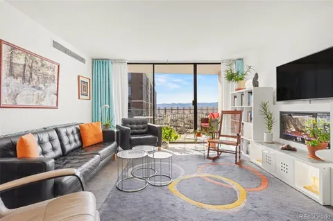 a living room with furniture large window and a flat screen tv